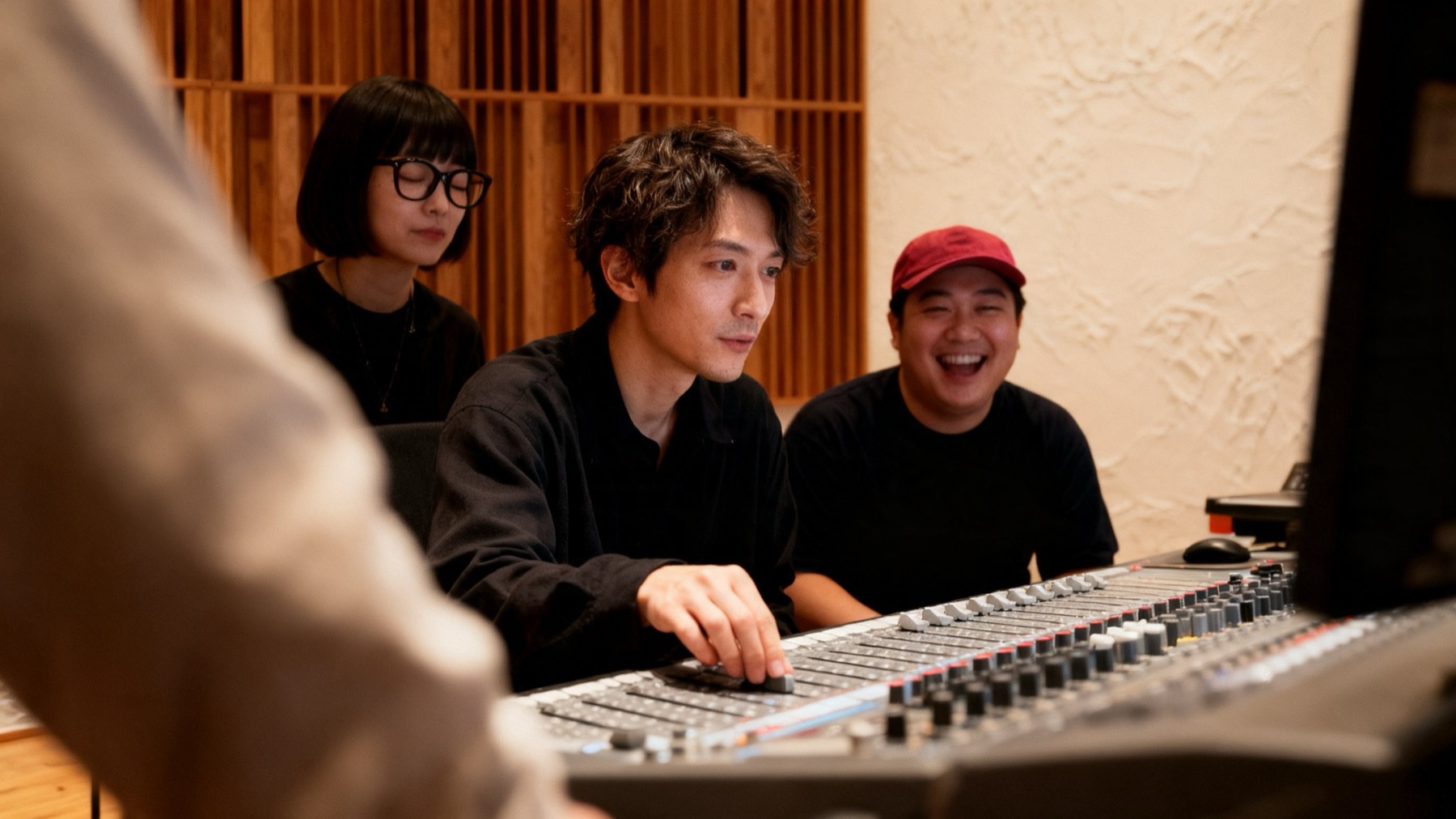 ミキサー卓を囲み、フェーダーを動かしながら音を聴く3人（イメージ）