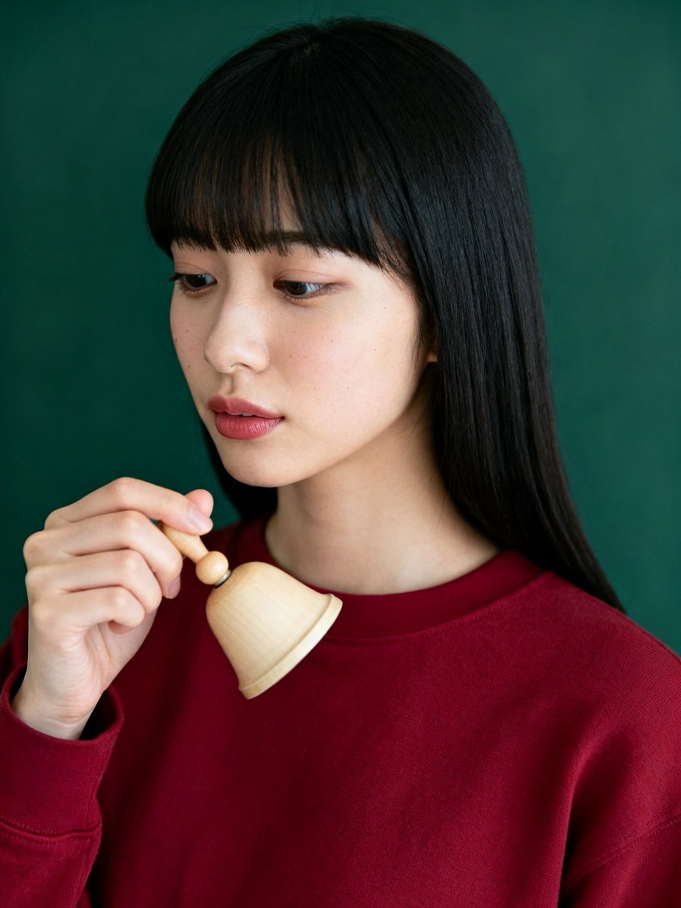 総務・20代女性。木の小さな鈴を鳴らす（イメージ・架空の人物）