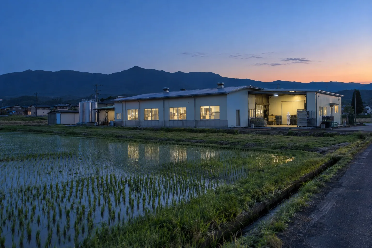 夜明け前の田園の中の工場