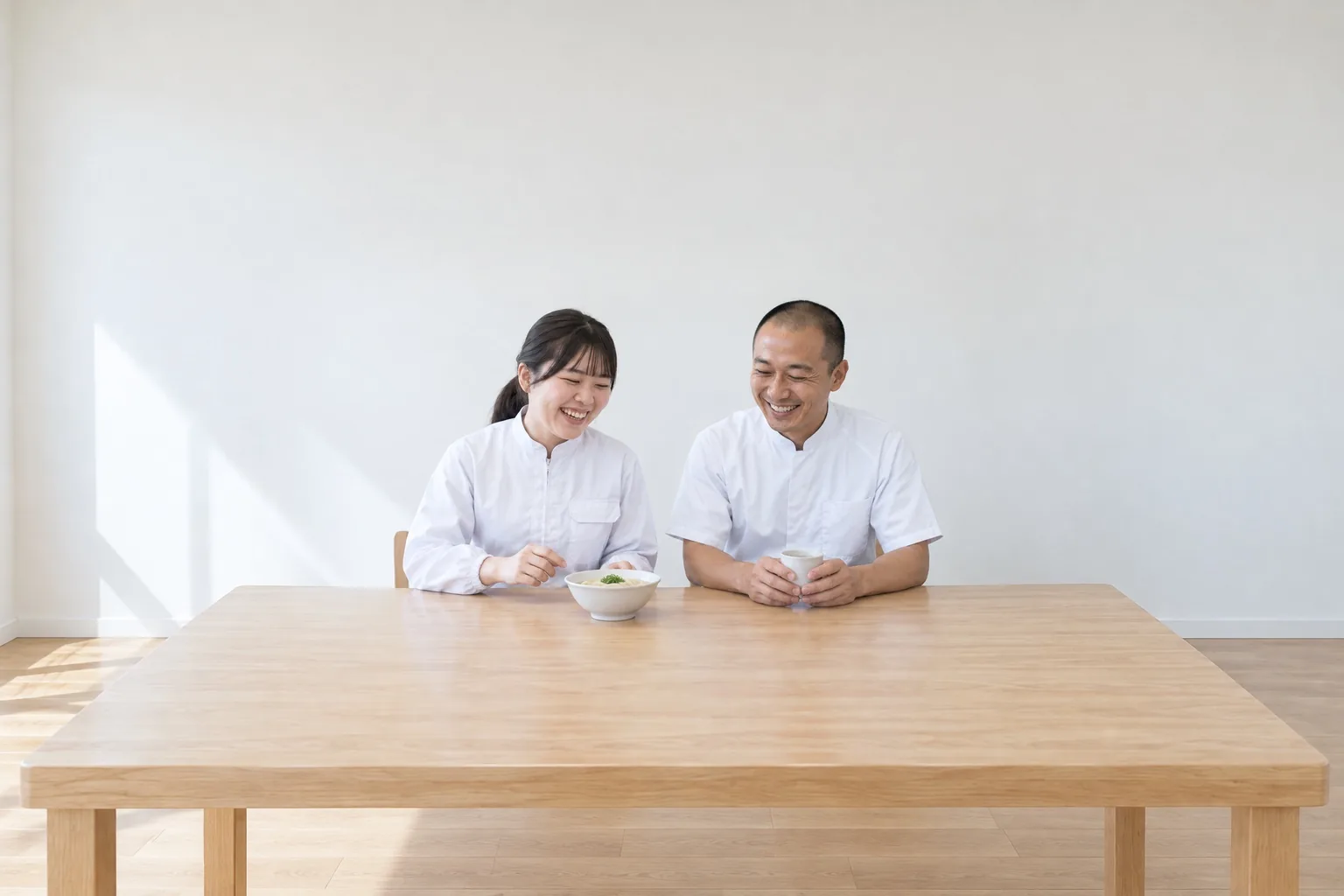 休憩室の長机で笑いながら話す製造の社員と製造課長