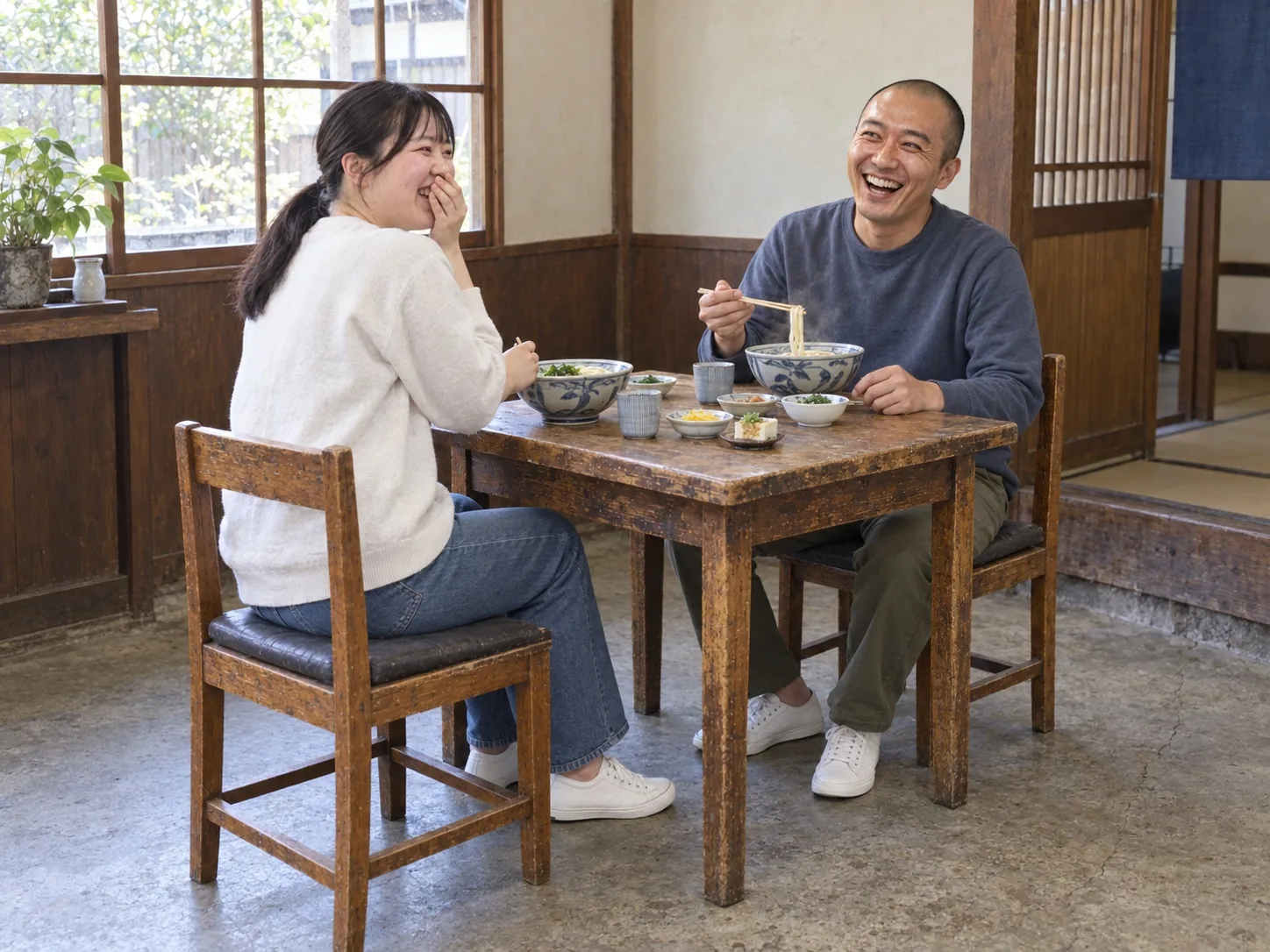定食屋でうどんを食べながら笑う製造課長と製造の社員
