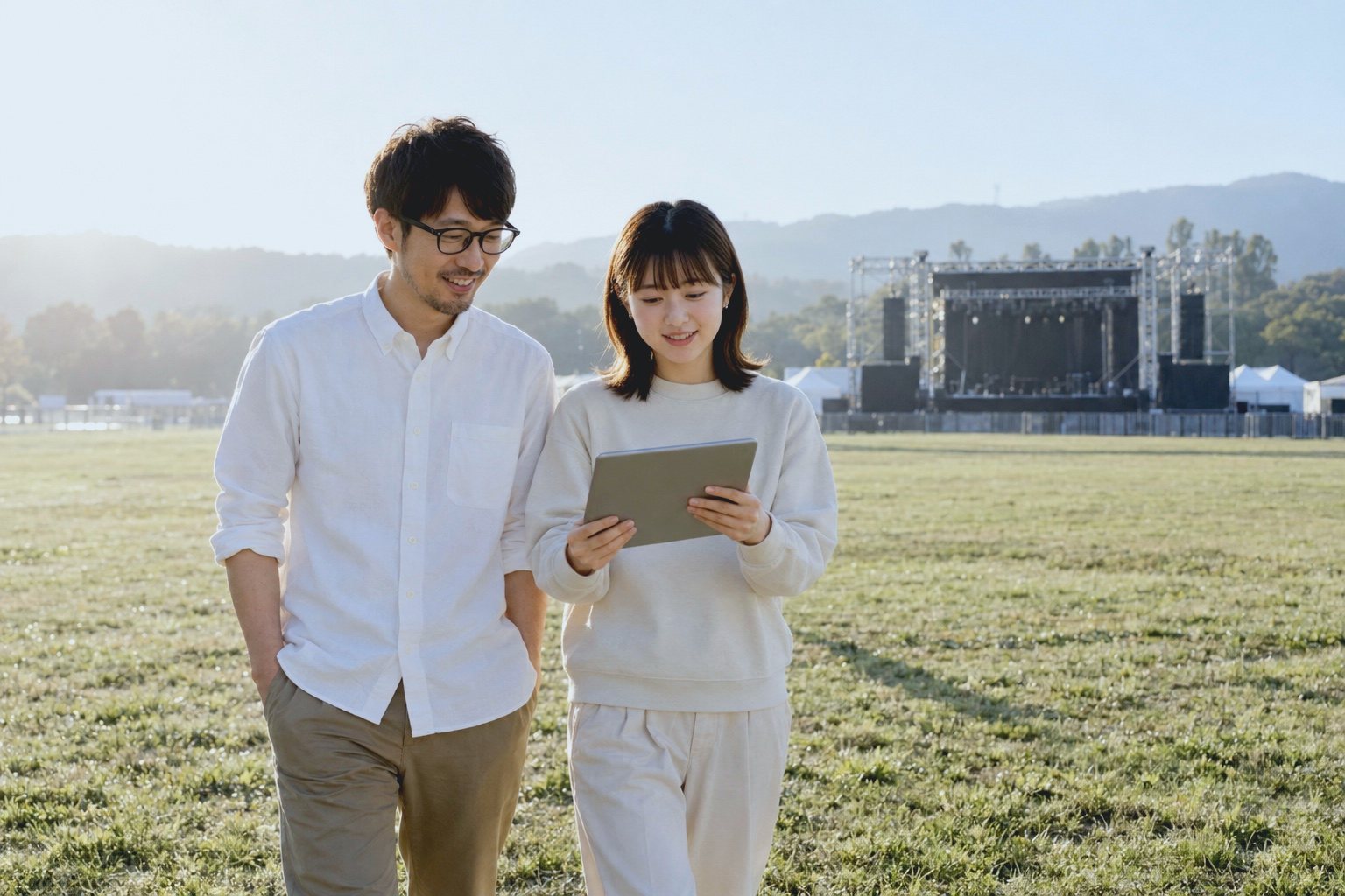 からっぽの客席エリアを歩きながら、タブレットで配置を確かめる2人